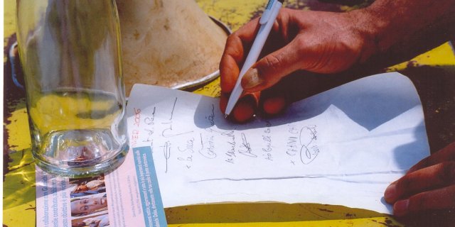 Rito tradizionale di inserimento di una bottiglia all'interno di una parte della struttura contenente i nomi delle autorità intervenute